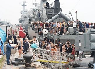 Tourists disembark from the HTMS Sukhothai in Sattahip after being rescued from flood-ravaged resorts in Koh Tao and Koh Phangan. Royal Thai Navy ships rescued more than 800 tourists who had been stranded there during the recent foul weather.